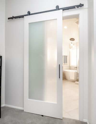 A white sliding barn door in a bathroom.