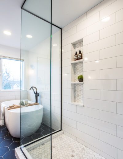 A white and black bathroom with a glass shower enclosure.